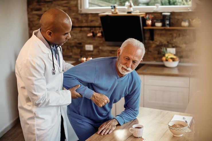 black doctor assisting senior man get up from chair nursing home 637285 11371